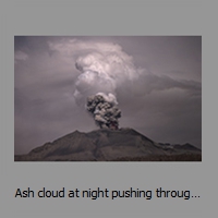 Ash cloud at night pushing through steam